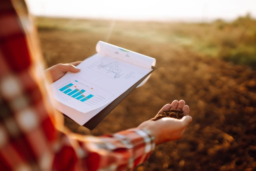 Hand of expert farmer collect soil and checking soil health before growth a seed of vegetable.